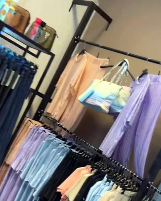 Rekken met pastelkleurige kleding in de showroom